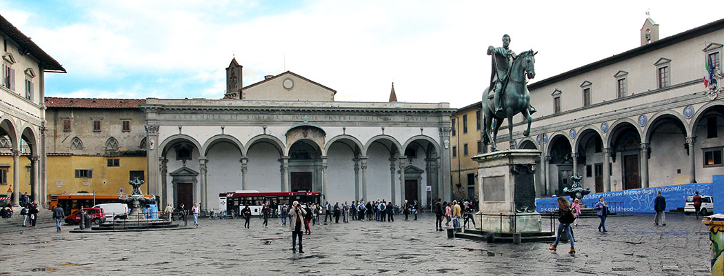Sehenswürdigkeiten von Florenz Die Piazza Santissima Annunziata mit Reiterstandbild von Ferdinando I. de Medici und den beiden Brunnen von Pietro Tacca. In der Mitte das Vorhaus der Kirche Santissima Annunziata, rechts das Ospedale degli Innocenti, links die Loggia von Antonio da Sangallo.