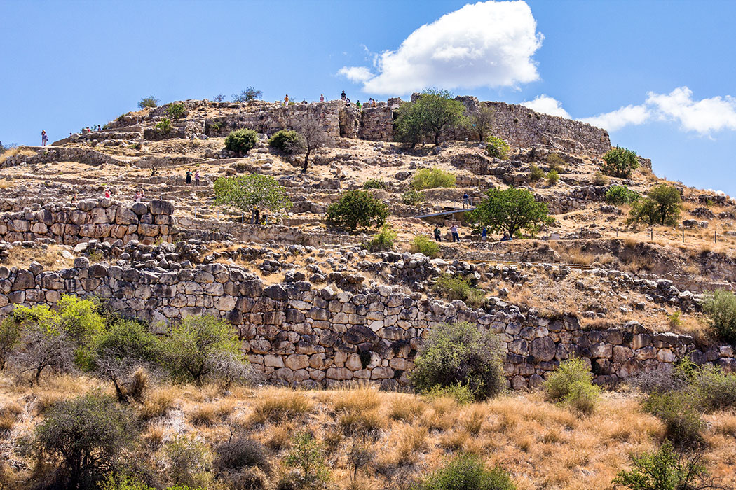 Mycenae citadel title argolis peloponnes greece Mykene: Blick auf die bronzezeitliche Zitadelle mit ihren wuchtigen Mauern. Die Besucher winden sich wie Ameisen hinauf zum Gipfel mit den Resten des königlichen Thronsaales.