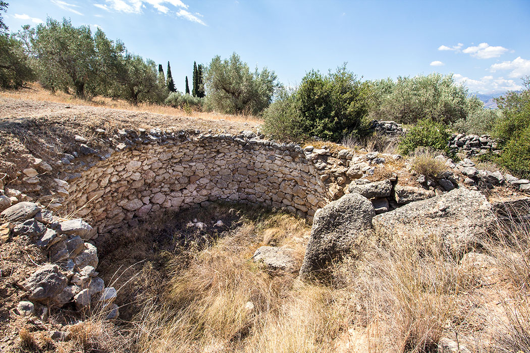 Mycenae cyclopean tholos tomb 01 panagitsa hill argolis peloponnes greece Das Kyklopen-Grab ist das älteste Tholosgrab von Mykene und wurde um 1500 v. Chr. errichtet. Die Decksteine des Torweges herabgestürzt, die eingestürzte Kuppel hatte einen Durchmesser von acht Metern. 