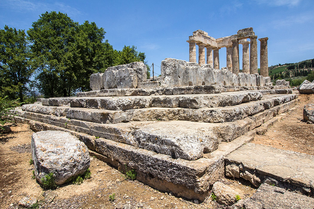 nemea sanctuary zeus korinthia peloponnes greece Die Hauptattraktion der Heiligtums von Nemea ist der dorische Zeustempel aus dem 4. Jhd. Der Tempel wird unter Verwendung der antiken Bauteile rekonstruiert und ergänzt. Von den ursprünglich zwei Säulen die noch aufrecht standen, sind zusätzlich sieben wieder aufgerichtet worden.