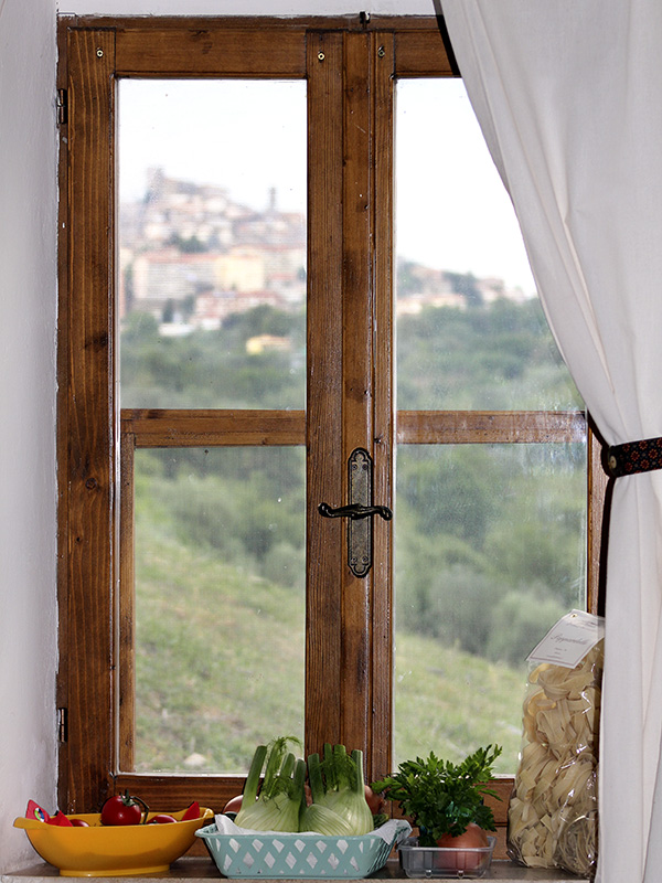 Fenster im Wohnraum, im Hintergrund der Blick auf Manciano.
