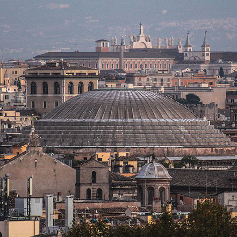 Die mächtige Kuppel des Pantheons, dahinter ragen die riesigen Heiligenfiguren des Laterans aus dem Dächermeer.