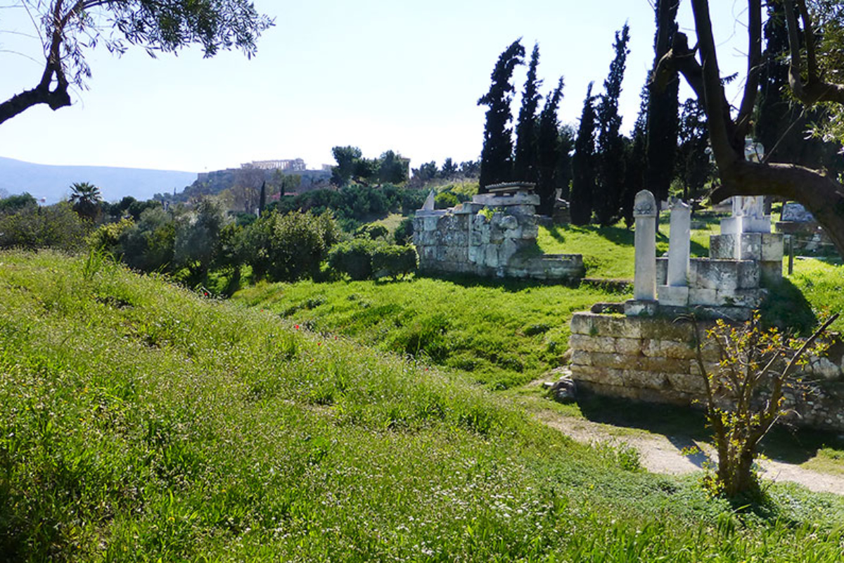 Der antike Kerameikos-Friedhof lag außerhalb der Stadtmauern. Die Akademiestraße beginnt am Dipylon-Tor und führt zur Akademeia, dem Sitz der von Platon begründeten Philosophenschule. Im Hintergrund ist das Parthenon sichtbar.