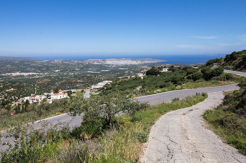 Panorama-Aussicht von der Dorfstraße in Kato Drys hinunter nach Stavromenos, die Stadt Sitia und das Meer. Ganz rechts die Inselgruppe der Dionysaden.