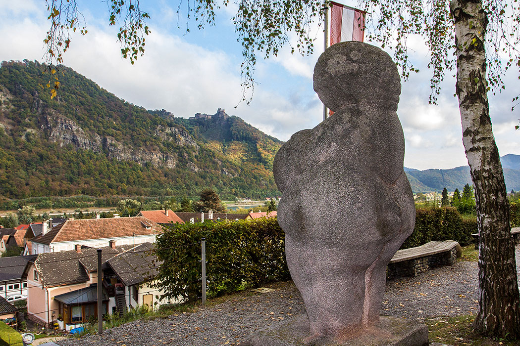 Eine Riesen-Venus blickt über Willendorf auf das Donautal. An dieser Stelle saßen die Steinzeitjäger um ihre große Feuerstelle, hier verlor einer der Jäger die kleine Frauenstatuette. Ein schöner, ehrwürdiger Platz!