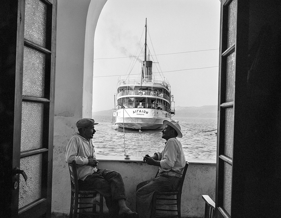 Insel Santorin: Männergespräche in der Hafenbar mit Blick auf das Dampfschiff "Aigaion". Foto © Robert McCabe